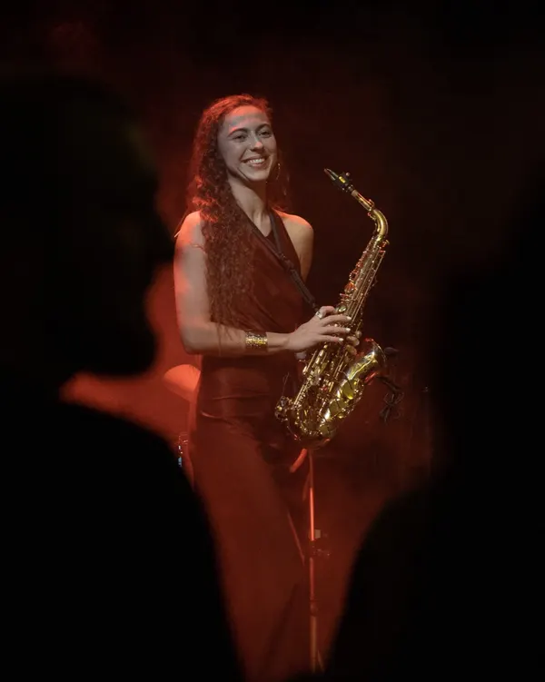 Eliška Milá se saxofonem na zahradní slavnosti